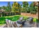 Backyard patio area with outdoor seating around a fire pit and green lawn at 4121 S Cherry St, Cherry Hills Village, CO 80113