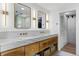 Elegant bathroom with dual sinks, marble countertops, custom wood cabinets, and stylish lighting fixtures at 4121 S Cherry St, Cherry Hills Village, CO 80113