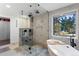 Beautiful bathroom featuring a glass enclosed shower, a luxurious soaking tub, and a large window at 4121 S Cherry St, Cherry Hills Village, CO 80113