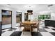 Dining area with a round table, woven chairs, and black-and-white checkered flooring adjacent to living space at 4121 S Cherry St, Cherry Hills Village, CO 80113