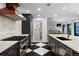 Stylish kitchen with stainless steel appliances, stone backsplash, a central island, and black and white floors at 4121 S Cherry St, Cherry Hills Village, CO 80113