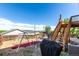 Spacious backyard features a deck with stairs and a swing set on a sunny day at 3296 S Bryant St, Englewood, CO 80110