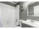 Clean bathroom features a shower-tub combo with white tile surround, gray walls, and a modern vanity at 3296 S Bryant St, Englewood, CO 80110