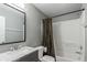 Well-lit bathroom features a marble vanity and a tub with shower and patterned curtain at 3296 S Bryant St, Englewood, CO 80110
