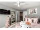 A well-lit bedroom features a full-length mirror, gray walls and a ceiling fan above the bed at 3296 S Bryant St, Englewood, CO 80110