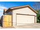 Spacious two-car garage with neutral siding and a well-maintained fence at 3296 S Bryant St, Englewood, CO 80110