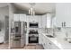 Modern kitchen with stainless steel appliances, white cabinets, and granite countertops, and tile floors at 3296 S Bryant St, Englewood, CO 80110