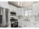 Updated kitchen featuring stainless steel appliances, white cabinetry, stylish backsplash, and large sink at 3296 S Bryant St, Englewood, CO 80110