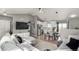 Open-concept living room with large sectional, flat-screen TV, and tile flooring adjacent to the modern kitchen at 3296 S Bryant St, Englewood, CO 80110