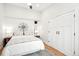 Bright main bedroom features a decorative wall compass, white brick wall, and hardwood floors at 3289 Perry St, Denver, CO 80212