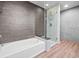 Bright bathroom featuring a tub with gray tile and a glass-enclosed shower at 891 14Th St # 3410, Denver, CO 80202