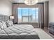 Calm bedroom with a plush bed, cityscape views, elegant drapery, and a modern nightstand at 891 14Th St # 3410, Denver, CO 80202