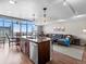 Open-concept living space with modern kitchen island, wood floors, and comfortable seating area at 891 14Th St # 3410, Denver, CO 80202