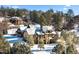 Luxury home covered in snow, nestled in a wooded area at 83 Castle Pines N Dr, Castle Rock, CO 80108