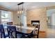 Cozy dining room with brick fireplace wall, modern lighting and backyard view at 9403 Southern Hills Cir, Lone Tree, CO 80124