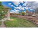 Lush backyard with a covered patio, mature plants, and black metal fencing offering privacy at 23808 E Bellewood Dr, Aurora, CO 80016