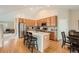 Open kitchen with hardwood floors, island with seating, stainless steel appliances, and ample cabinetry at 23808 E Bellewood Dr, Aurora, CO 80016