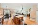 Bright, open kitchen featuring a center island, stainless steel appliances, and hardwood floors flowing into the living area at 23808 E Bellewood Dr, Aurora, CO 80016