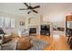 Inviting living room with hardwood floors, a cozy fireplace, neutral paint, and seamless flow into the kitchen at 23808 E Bellewood Dr, Aurora, CO 80016