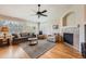 Comfortable living room with hardwood floors, large windows with shutters, a fireplace, and neutral decor at 23808 E Bellewood Dr, Aurora, CO 80016