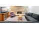 Finished basement with stacked stone fireplace and comfortable seating area with a grey sofa at 1100 Pontiac St, Denver, CO 80220
