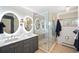 Elegant bathroom with double vanity, lighted mirrors, glass enclosed shower, and tiled floors at 1100 Pontiac St, Denver, CO 80220