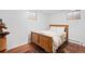 This bedroom features a wood frame bed, hardwood floors and two windows for great natural light at 1100 Pontiac St, Denver, CO 80220
