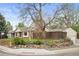 Landscaped yard with stone accents frames a brick home with a detached garage and wooden privacy fence at 1100 Pontiac St, Denver, CO 80220
