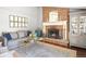 Cozy living room featuring a brick fireplace, hardwood floors, stylish decor, and comfortable seating at 1100 Pontiac St, Denver, CO 80220