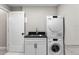 Bright laundry room with stacked Miele washer/dryer and modern sink at 741 Green Mountain Dr, Erie, CO 80516
