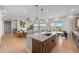 Bright, open-concept living room featuring a large kitchen island, hardwood floors, and modern decor at 741 Green Mountain Dr, Erie, CO 80516