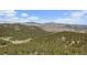 Breathtaking aerial view of vast forest landscape and snow-capped mountain range at 513 Mt Blue Sky Rd, Golden, CO 80401