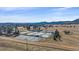 An aerial view shows multiple tennis courts, rolling hills, and mountain views in this highly desirable Colorado community at 513 Mt Blue Sky Rd, Golden, CO 80401