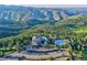 Breathtaking aerial view of luxury property with mountain backdrop, pool, and generous parking at 513 Mt Blue Sky Rd, Golden, CO 80401