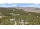 Scenic aerial view of mountain home nestled among trees with mountain range in the background at 513 Mt Blue Sky Rd, Golden, CO 80401