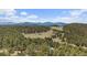 Breathtaking aerial view of rolling hills with lush forest landscape and blue sky at 513 Mt Blue Sky Rd, Golden, CO 80401