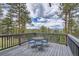 Enjoy the mountain views from this deck with seating for four surrounded by tall pines and topped by a partly cloudy sky at 513 Mt Blue Sky Rd, Golden, CO 80401