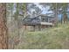 This exterior elevation shows a two-story home with a sunroom, a deck, and a stone foundation on a sloped lot at 513 Mt Blue Sky Rd, Golden, CO 80401