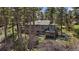 Exterior shot of gray house with sunroom attached in wooded area at 513 Mt Blue Sky Rd, Golden, CO 80401