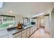 Bright kitchen with granite countertops, white cabinetry and a skylight at 513 Mt Blue Sky Rd, Golden, CO 80401