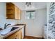 Compact kitchen features wood cabinets, stainless steel sink and a window with a forest view at 513 Mt Blue Sky Rd, Golden, CO 80401