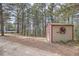 A cute outdoor shed with white trim, a window and a decorative wreath adds storage and charm to this treed lot at 513 Mt Blue Sky Rd, Golden, CO 80401