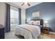 Comfortable bedroom features a queen bed, blue accents, and natural light at 8505 S Tibet Ct, Aurora, CO 80016