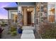 Inviting front porch with stone accents and colorful planters creating a welcoming entrance at 8505 S Tibet Ct, Aurora, CO 80016