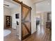 Living room featuring a decorative barn door and hardwood floors at 8505 S Tibet Ct, Aurora, CO 80016