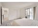 Light-filled bedroom with sliding glass doors to the balcony, carpet flooring, and closet at 19558 E Purdue Pl, Aurora, CO 80013