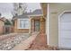 Inviting home entrance featuring brick accents, well maintained landscaping, and a security screen door at 19558 E Purdue Pl, Aurora, CO 80013