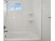 This bathroom features white subway tile and a shower tub combo with shelving at 6337 W 68Th Pl, Arvada, CO 80003