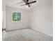 Cozy bedroom with neutral walls, gray carpet, modern ceiling fan, and a window overlooking a tree-lined yard at 6337 W 68Th Pl, Arvada, CO 80003