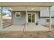Covered patio with a concrete floor, sliding glass door, and windows on the gray house at 6337 W 68Th Pl, Arvada, CO 80003